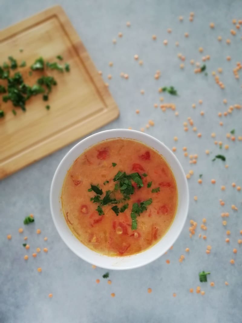 Zupa z czerwonej soczewicy i pomidorów posypana natką pietruszki